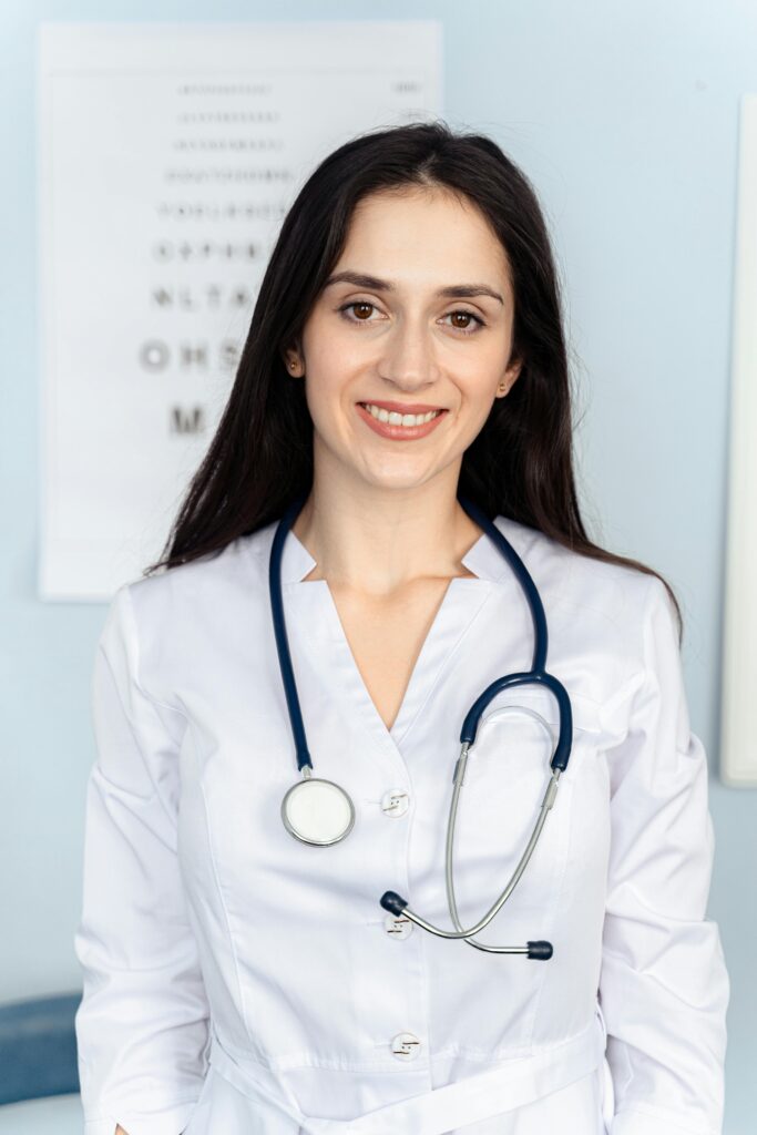 Smiling female doctor with stethoscope in a clinic setting. Warm, professional ambiance.
